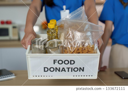 Food Donation Collection. Volunteers showcasing food items for community support. Food Donation Collection. Volunteers showcasing food items for community support. 133672111