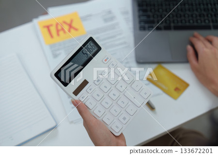 Tax preparation. Using calculator and documents for financial planning. 133672201