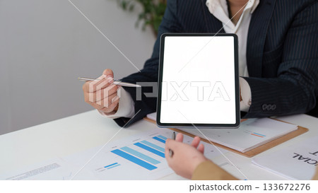 Digital Presentation. Business professional showcasing data on a tablet during a meeting. Digital Presentation. Business professional showcasing data on a tablet during a meeting. 133672276