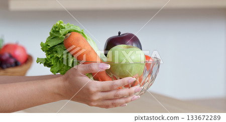 Food Wellness: Holding a Bowl of Fresh Fruits and Vegetables 133672289