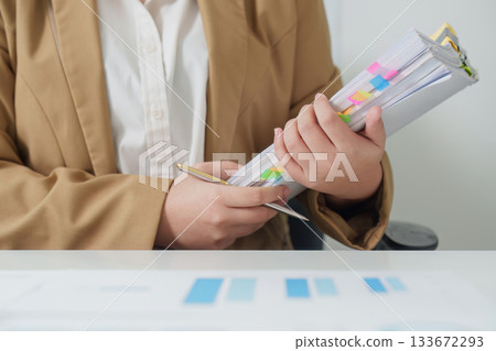 Document Preparation. Business professional holding organized files and preparing for a meeting. 133672293