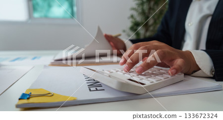 Financial Management. Professional calculating financial data while reviewing documents. Financial Management. Professional calculating financial data while reviewing documents. 133672324