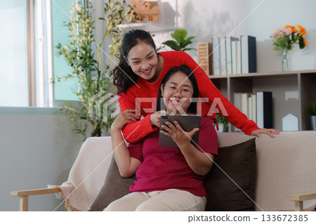Digital connection. Young woman and her mother sharing moments on a tablet. 133672385