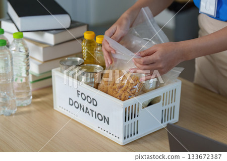 Food Donation. Volunteers organizing food items for community support. 133672387
