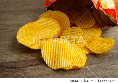 Potato chips in open bag, delicious BBQ seasoning spicy for crips, thin slice deep fried snack fast food. Potato chips in open bag, delicious BBQ seasoning spicy for crips, thin slice deep fried snack fast food. 133672472