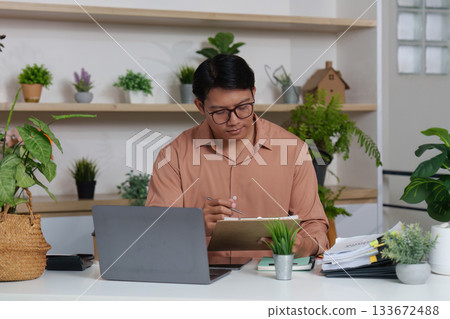 Remote Work. Professional analyzing financial data in a modern home office. Remote Work. Professional analyzing financial data in a modern home office. 133672488