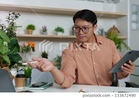 Digital Strategy. Professional discussing financial insights using tablet in modern office. Digital Strategy. Professional discussing financial insights using tablet in modern office. 133672490