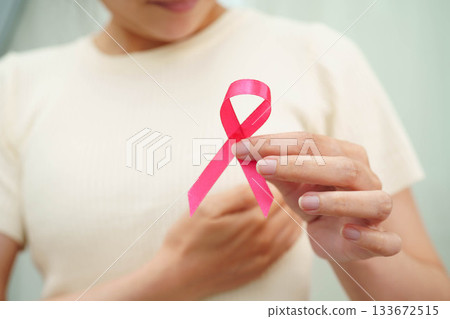 Asian woman with pink ribbon for October world breast cancer day. Asian woman with pink ribbon for October world breast cancer day. 133672515