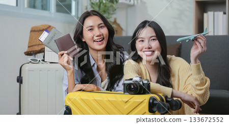 Travel Planning. Two friends posing with their passports and travel gear, ready for adventure. 133672552