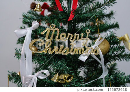Merry Christmas Sign on Decorated Tree with Ribbons Merry Christmas Sign on Decorated Tree with Ribbons 133672618