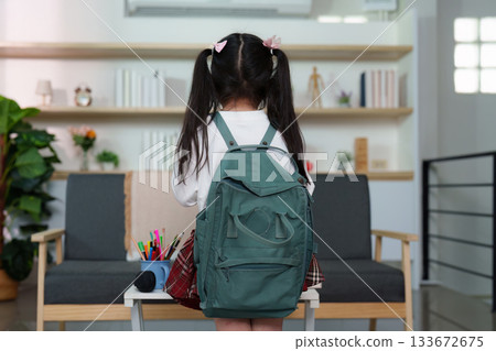 Back to School. Young girl with backpack facing away, ready for school in modern home. 133672675