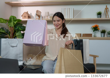 Shopping Success with Cat. Woman showcasing her shopping bags with a smile. 133672677