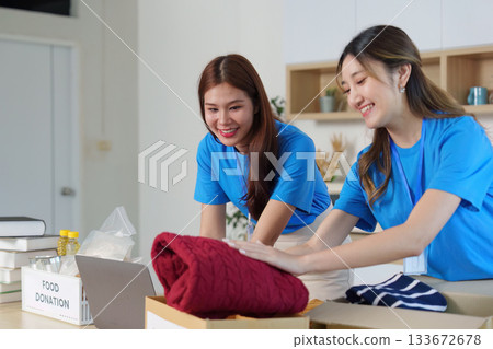 Community volunteers folding clothes for donation Community volunteers folding clothes for donation 133672678
