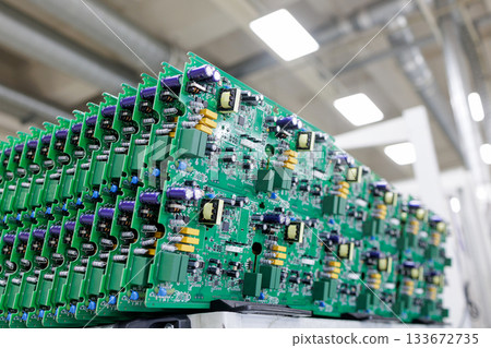 Rows of assembled green printed circuit boards with power electronics components in modern automated manufacturing plant 133672735