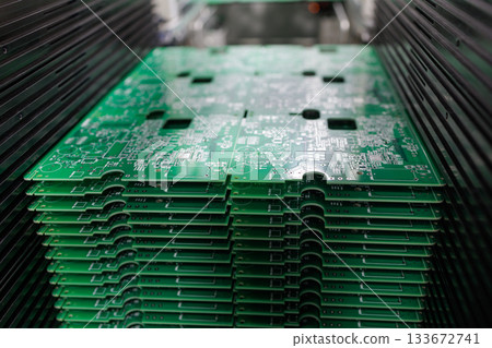 Closeup view of stack of green printed circuit boards in modern electronics manufacturing plant concept of technology industry production 133672741