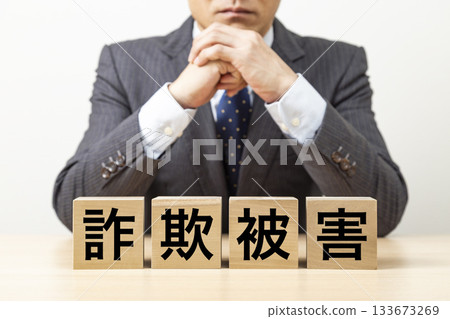 A block with the word "fraud victim" written on it and a businessman 133673269