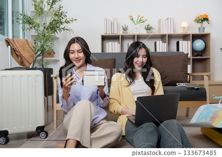 Travel Planning. Two friends organizing their trip together with smiles. Travel Planning. Two friends organizing their trip together with smiles. 133673485