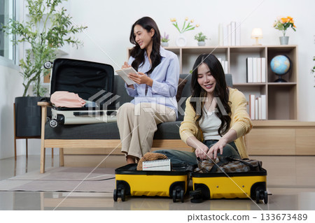 Travel Planning: Friends packing luggage together for an exciting trip Travel Planning: Friends packing luggage together for an exciting trip 133673489