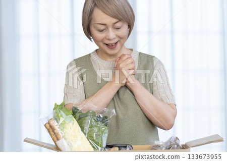 一位老婦人欣喜地看著農場直接把蔬菜送到她家客廳。 133673955