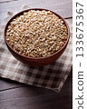 Uncooked Whole Oats in Beige Bowl on Wooden Background Close Up Uncooked Whole Oats in Beige Bowl on Wooden Background Close Up 133675367
