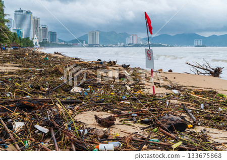 Piles of garbage and waste on beach by the sea after a storm in Nha Trang in Vietnam in cloudy rainy weather. Environmental disaster 133675868
