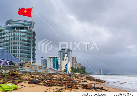 Piles of garbage and waste on beach by the sea after a storm in Nha Trang in Vietnam in cloudy rainy weather. Environmental disaster 133675873