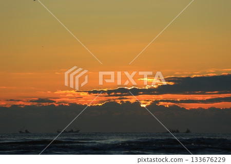 日出時分,雲朵漂浮在海面上。 日出時分,雲朵漂浮在海面上。 133676229