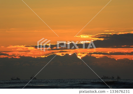 日出時分,雲朵漂浮在海面上。 日出時分,雲朵漂浮在海面上。 133676231