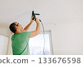 Man using electric drill to 133676598