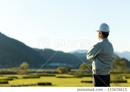 一位中年男性商務人士穿著工作服站在戶外。 一位中年男性商務人士穿著工作服站在戶外。 133676615