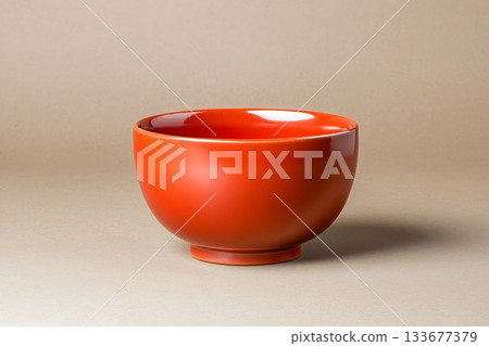 Bright Red Ceramic Bowl on Smooth Neutral Background for Table Setting and Interior Decor 133677379