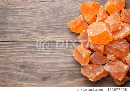 Orange Rock Salt Pieces on Wooden Surface, Natural Mineral for Cooking and Decoration 133677408