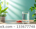 Fresh Water Glass with Green Leaves and Goji Berries on a Wooden Table in Bright Room Fresh Water Glass with Green Leaves and Goji Berries on a Wooden Table in Bright Room 133677748