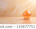 Elegant Transparent Orange Sphere on Smooth Marble Background for Modern Design Projects Elegant Transparent Orange Sphere on Smooth Marble Background for Modern Design Projects 133677751