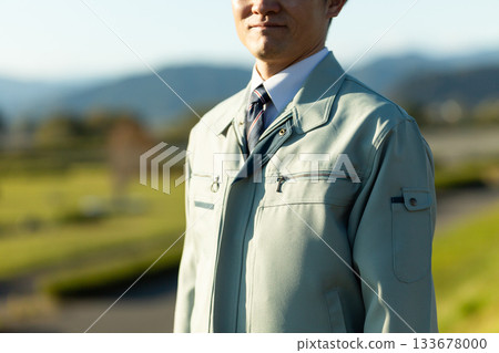 A middle-aged male businessman standing outdoors wearing work clothes A middle-aged male businessman standing outdoors wearing work clothes 133678000