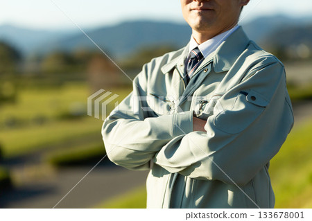 A middle-aged male businessman standing outdoors wearing work clothes A middle-aged male businessman standing outdoors wearing work clothes 133678001