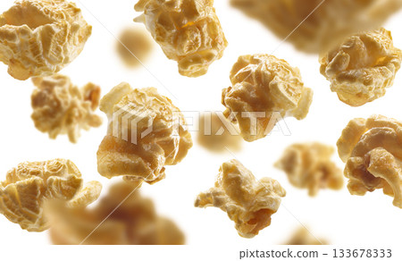 Caramel-flavored popcorn levitates on a white background Caramel-flavored popcorn levitates on a white background 133678333