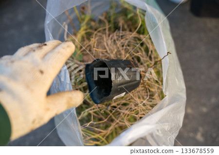 Throw away the flower pots in a garbage bag 133678559