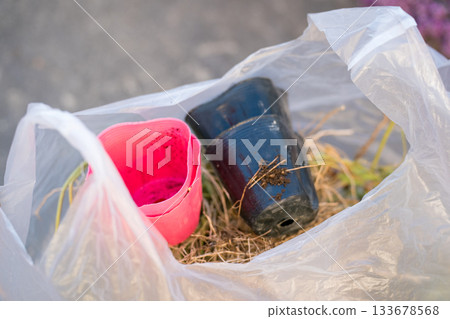 Throw away the flower pots in a garbage bag Throw away the flower pots in a garbage bag 133678568