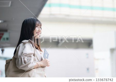 Smiling young woman holding a passport for overseas travel and departure scene 133678742