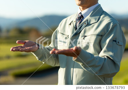 A middle-aged male businessman standing outdoors wearing work clothes 133678793