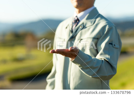 A middle-aged male businessman standing outdoors wearing work clothes A middle-aged male businessman standing outdoors wearing work clothes 133678796