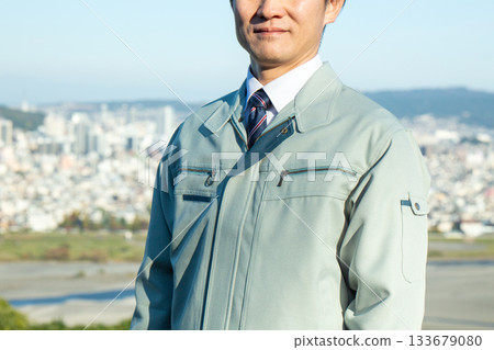 A middle-aged male businessman standing outdoors wearing work clothes A middle-aged male businessman standing outdoors wearing work clothes 133679080
