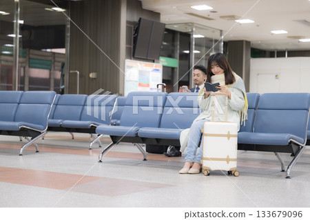 一位身著冬裝、手持護照的年輕女子,準備出國旅行歡度新年假期。 一位身著冬裝、手持護照的年輕女子,準備出國旅行歡度新年假期。 133679096