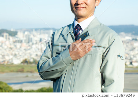 A middle-aged male businessman standing outdoors wearing work clothes 133679249