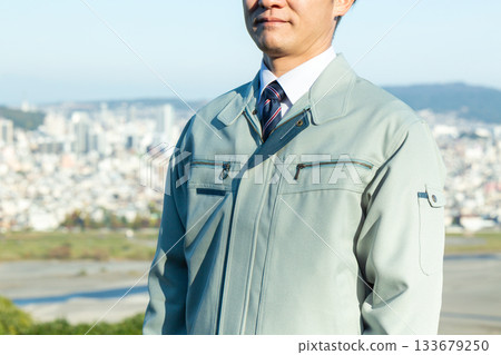 A middle-aged male businessman standing outdoors wearing work clothes A middle-aged male businessman standing outdoors wearing work clothes 133679250
