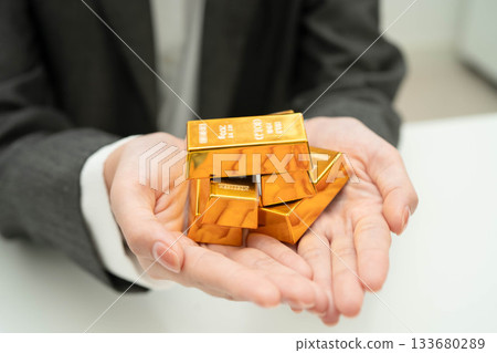 Asian woman holding gold bar in finance business. Asian woman holding gold bar in finance business. 133680289