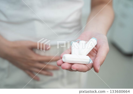 Asian woman holding cotton tampons for hygiene menstrual period cycle protection. Asian woman holding cotton tampons for hygiene menstrual period cycle protection. 133680664