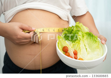 Asian woman with fat belly big size overweight and obesity with healthy food. 133680665