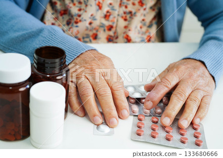 Asian elderly woman holding pill drug with water in glass, strong healthy medical. 133680666